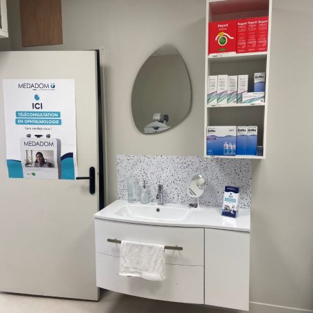 Salle de bain moderne avec lavabo, miroir et étagères de produits de soins.